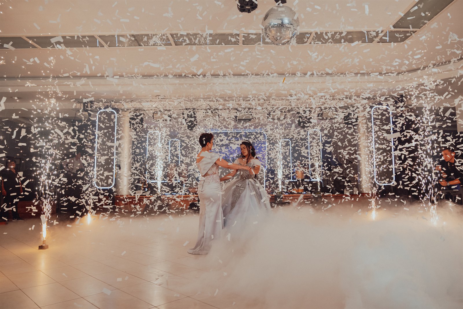 Una celebración con baile, luces y confeti en un salón