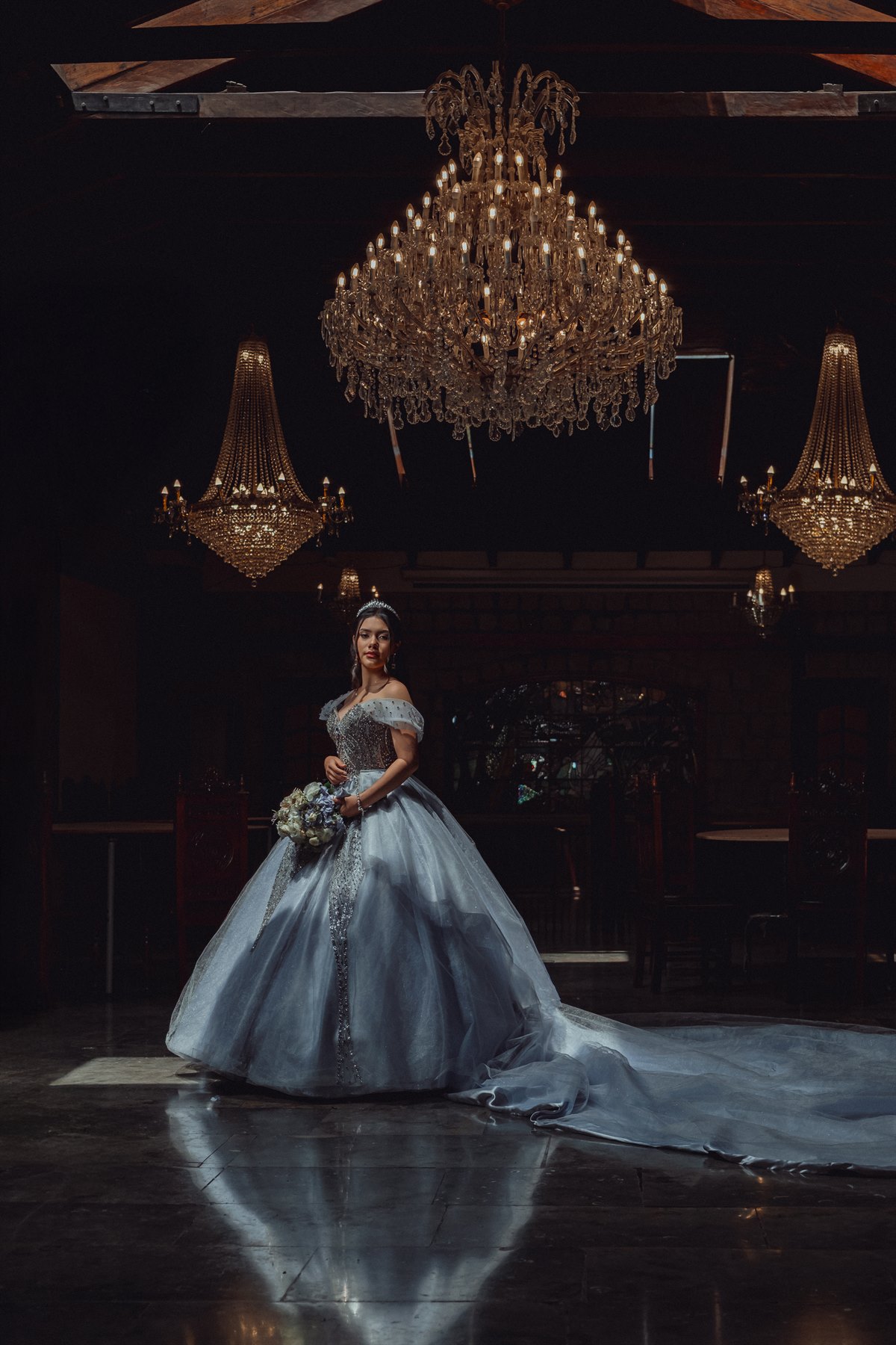 Una quinceañera bajo las lámparas de un salón de celebración